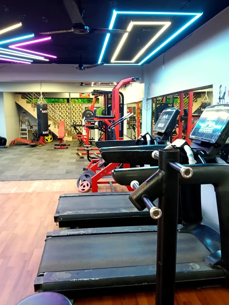 Cardio equipment and treadmills under modern lighting at Arya Fitness